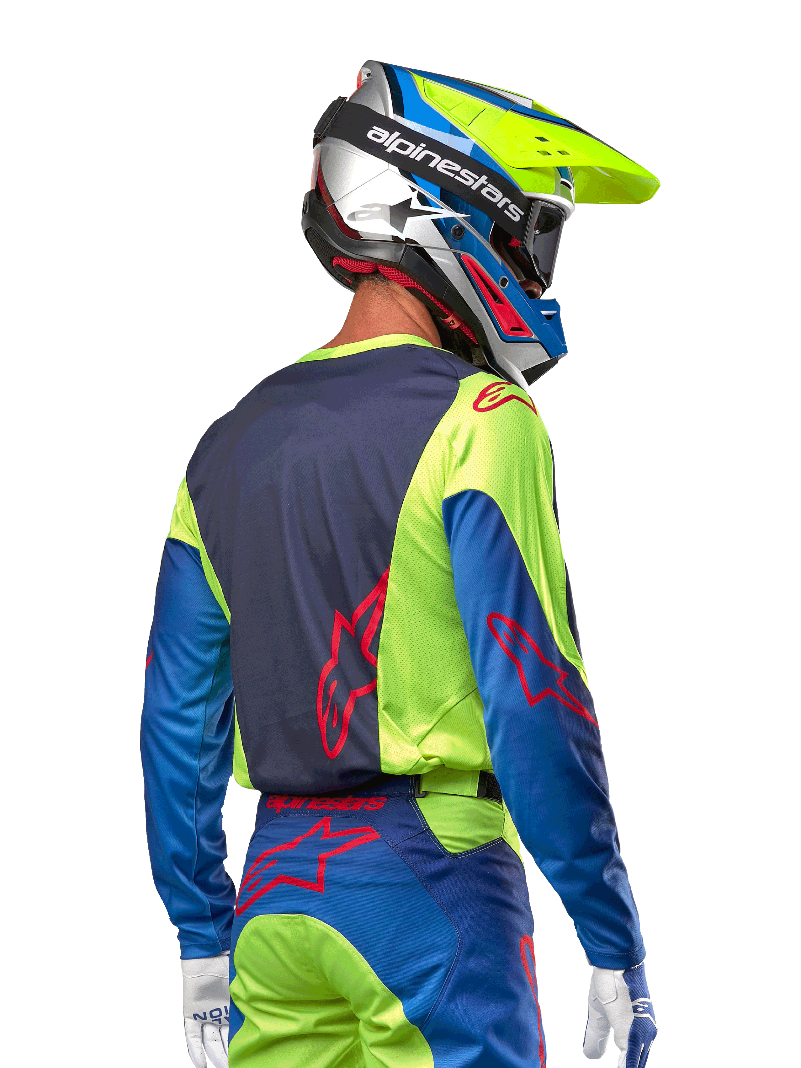 Motocrossförare som bär Alpinestars 2024 Racer Hoen Jersey i Yellow Fluo och Blue Night Navy, med en röd stjärnlogotyp på ryggen, matchande motocrossbyxor och en koordinerad racinghjälm, ryggvy som visar den ergonomiska designen för terrängprestanda.