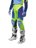 Alpinestars 2024 Racer Hoen Pants, Motocross Pants, Yellow Fluo and Blue Night Navy, featuring red star logos and black inner knee panels, worn with a matching jersey and white motocross boots, performance gear for off-road racing