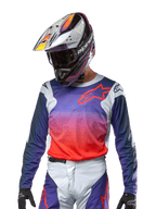 Alpinestars 2024 Racer Hoen Jersey, motocrosströja, lila och starkt orange gradient med mörkblå ärmar, ljusgrå axelpaneler, bärs med matchande racingbyxor och hjälm, komplett utrustning för terrängkörning