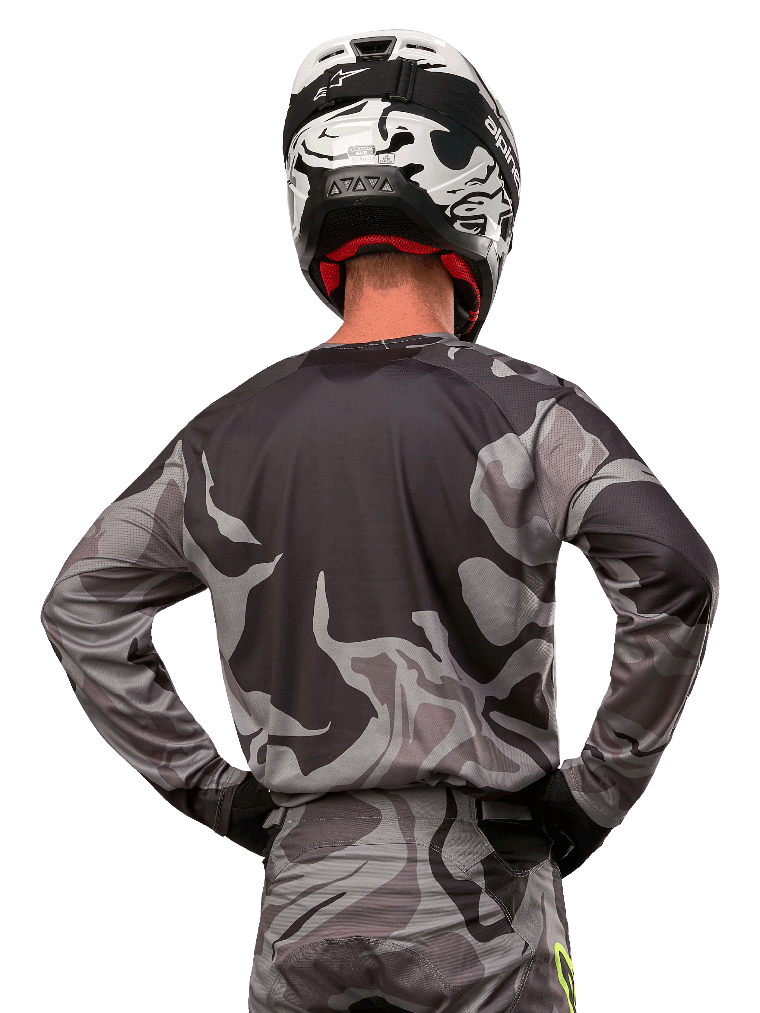 Alpinestars 2024 Racer Tactical-tröja, motocrosströja, Cast Gray Camo Magnet, ryggvy som visar grått och svart kamouflagemönster, bärs med matchande byxor och en svartvit hjälm, professionell racingutrustning för terrängkörning