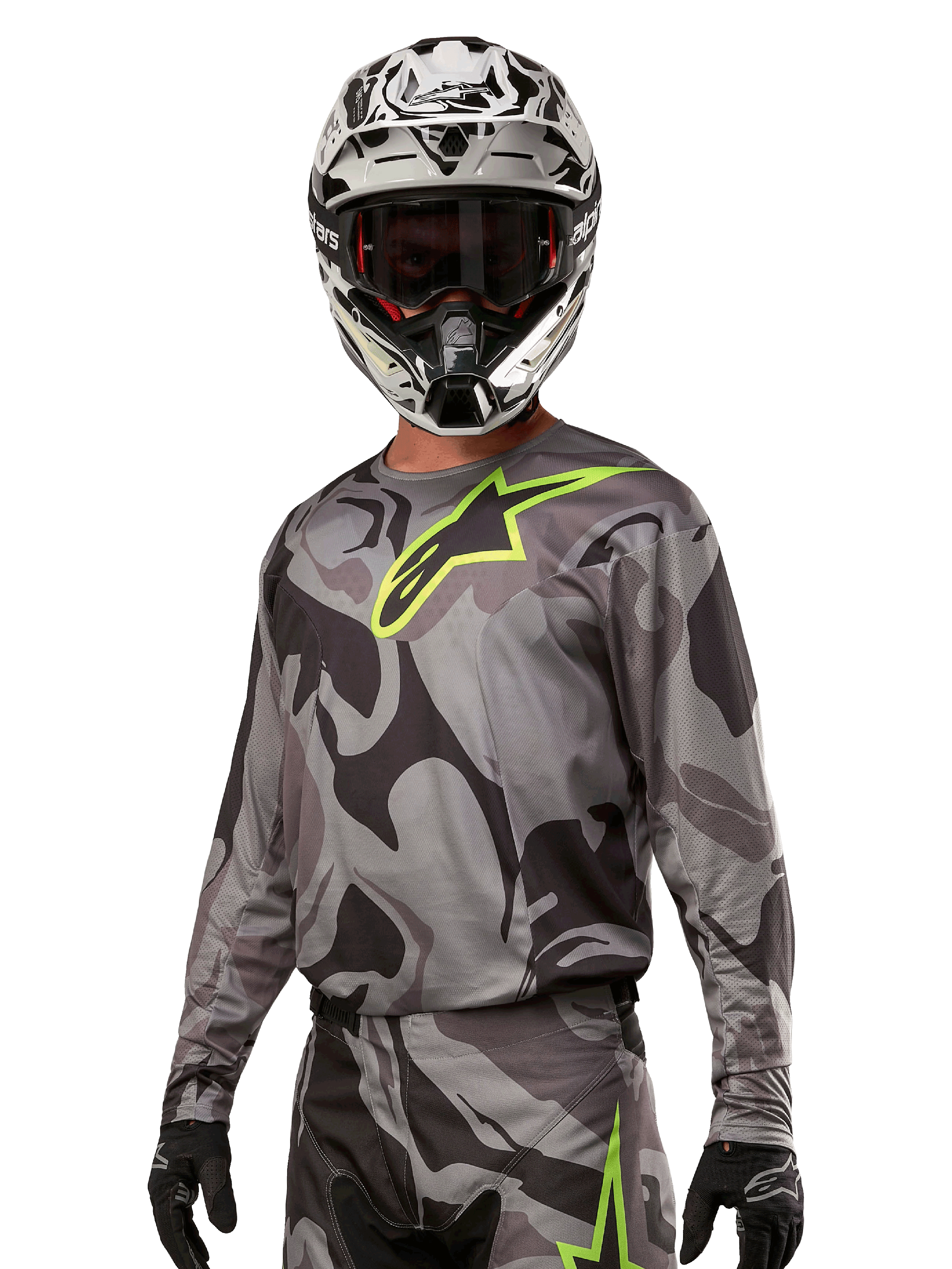 Alpinestars 2024 Racer Tactical Jersey, motocrosströja, grått kamouflagemönster med neongrön logotyp, bärs med svartvit hjälm och svarta handskar, tekniskt fukttransporterande material för terrängkörning