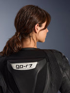 Alpinestars Stella GP-R7 2-delat läderställ, svart, närbild av ryggen med GP-R7-logotyp på den aerodynamiska puckeln, dragspelsformade stretchpaneler i läder på axlarna, racingkonstruktion för damer