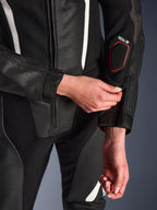 Närbild av Alpinestars Stella GP-R7 2-delat läderställ i svart, med fokus på dragkedjejustering vid underarmen, perforerad läderkonstruktion, vita detaljer och Tech-Air-kompatibel märkning på ärmen.