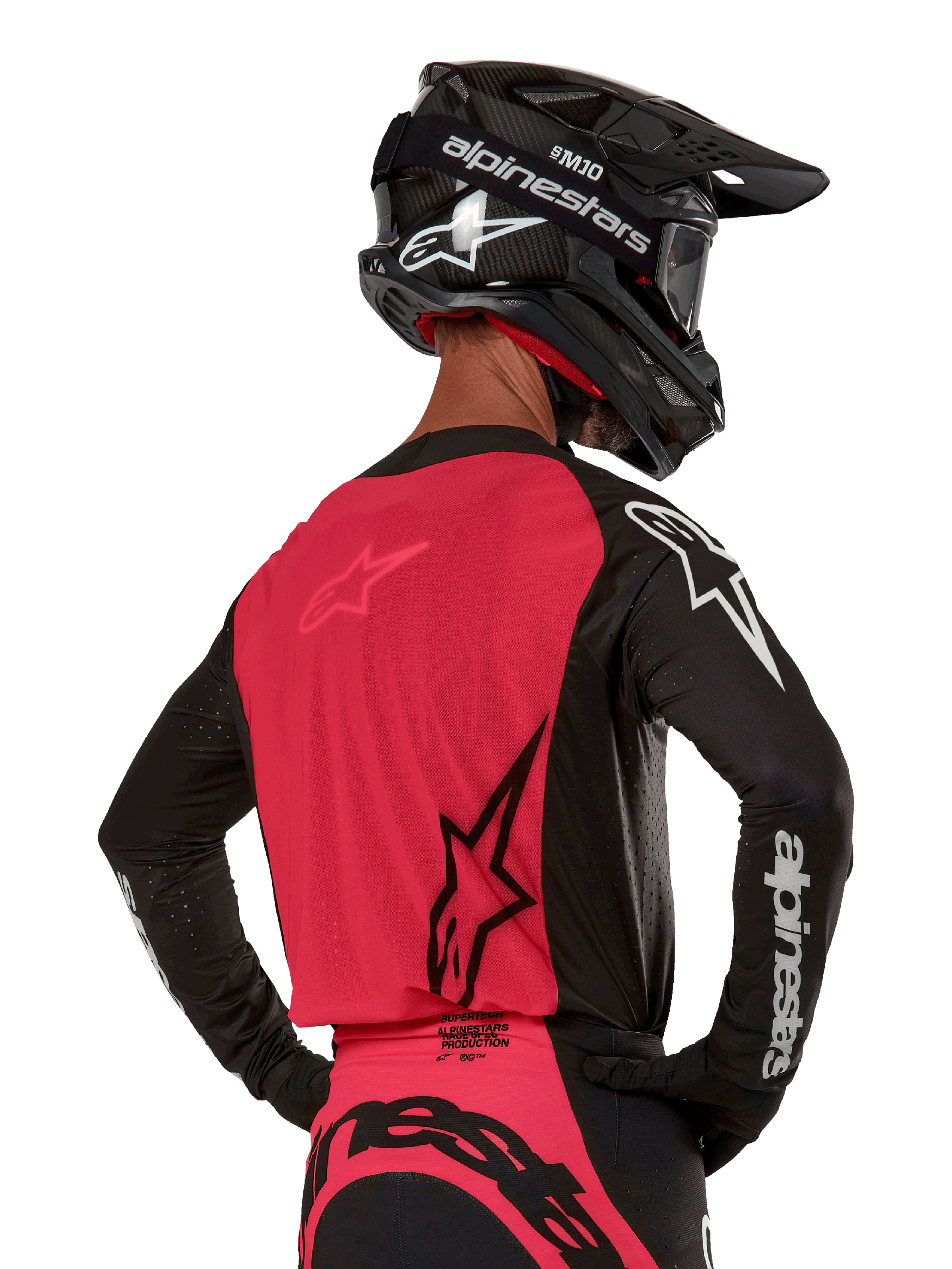 Alpinestars 2024 Supertech Ward Jersey, Motocross Jersey, Black and Red Berry, back view showing red mesh panel and black sleeves with white branding, worn with a black carbon fiber helmet and gloves, athletic race fit for off-road riding
