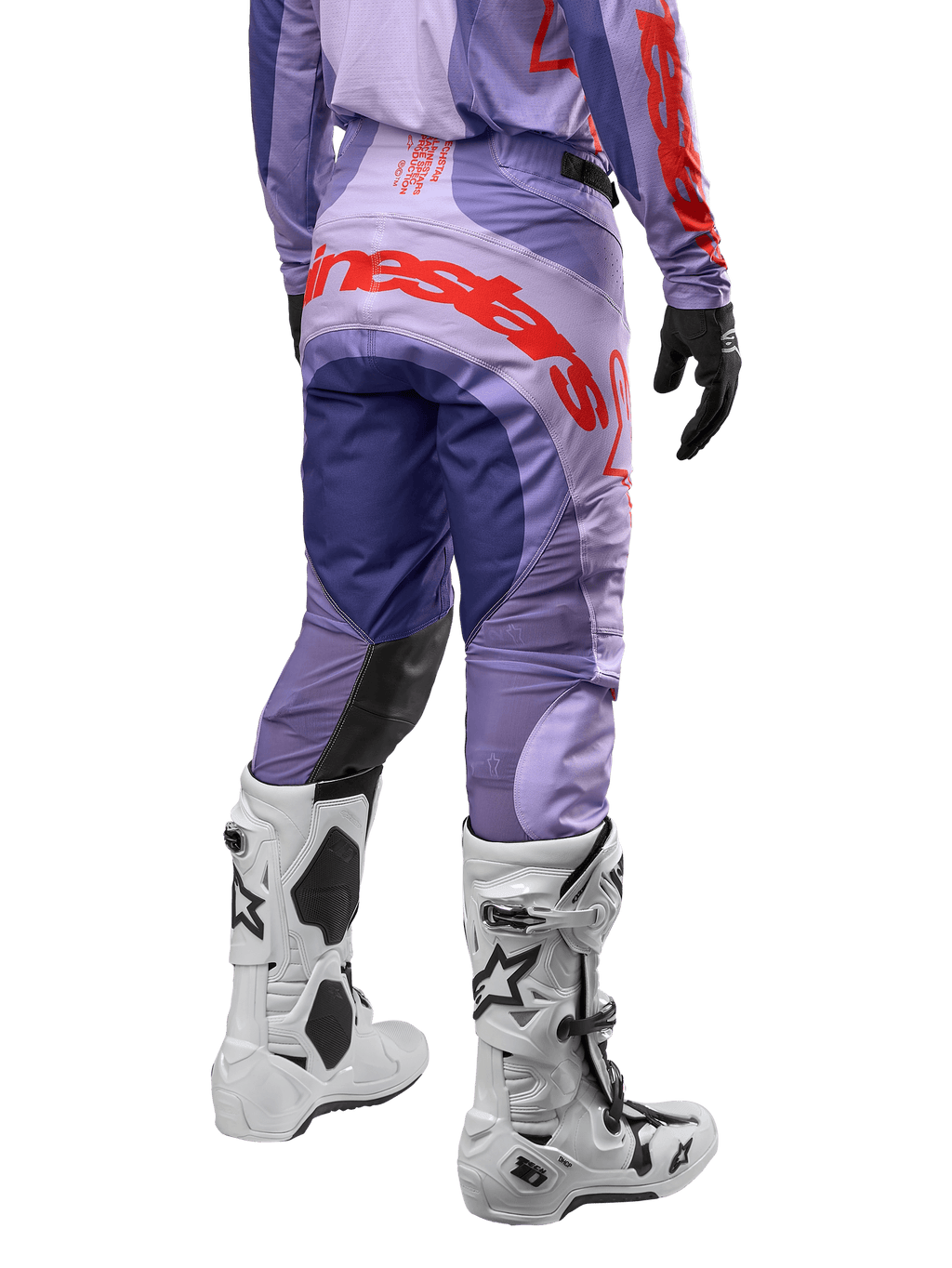 Alpinestars 2024 Techstar Ocuri byxor, motocrossbyxor i lila med hot orange detaljer, vy bakifrån som visar den stora röda logotypen på sätet, vita Tech 10-stövlar, svarta handskar, prestandamaterial för motocross.