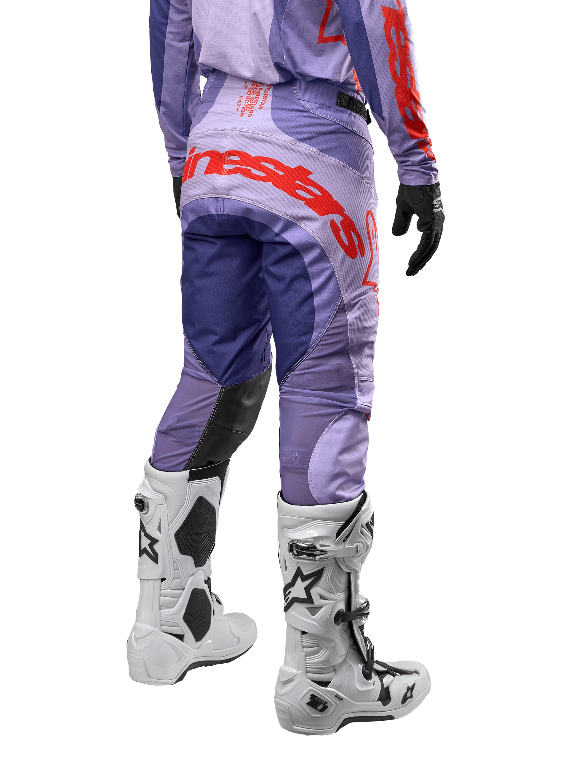 Alpinestars 2024 Techstar Ocuri byxor, motocrossbyxor i lila med hot orange detaljer, vy bakifrån som visar den stora röda logotypen på sätet, vita Tech 10-stövlar, svarta handskar, prestandamaterial för motocross.