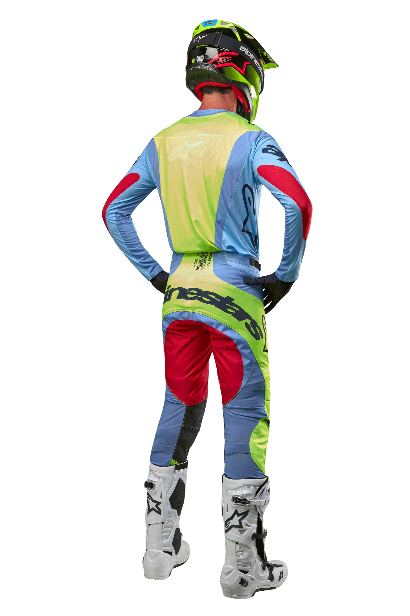 Motocrossförare sedd bakifrån iförd 2024 Techstar Ocuri-byxor och matchande tröja, ljusblå, fluorescerande gul och Red Berry, vita och svarta stövlar, svart hjälm med neondetaljer, koordinerad Alpinestars-utrustning för terrängkörning