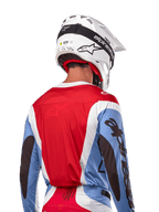 Alpinestars 2024 Techstar Ocuri Jersey, Motocross Jersey, Light Blue, Mars Red and White, rear view of rider wearing matching white helmet and black goggles, features bold black branding on sleeves and ergonomic race fit for off-road performance