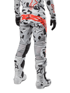 Alpinestars 2024 Techstar Rantera-byxor, motocrossbyxor, Haze Gray Camo, med svarta kamouflagemönster och en stor röd Alpinestars-logotyp på sätet, sedda bakifrån tillsammans med vita stövlar och matchande racingutrustning
