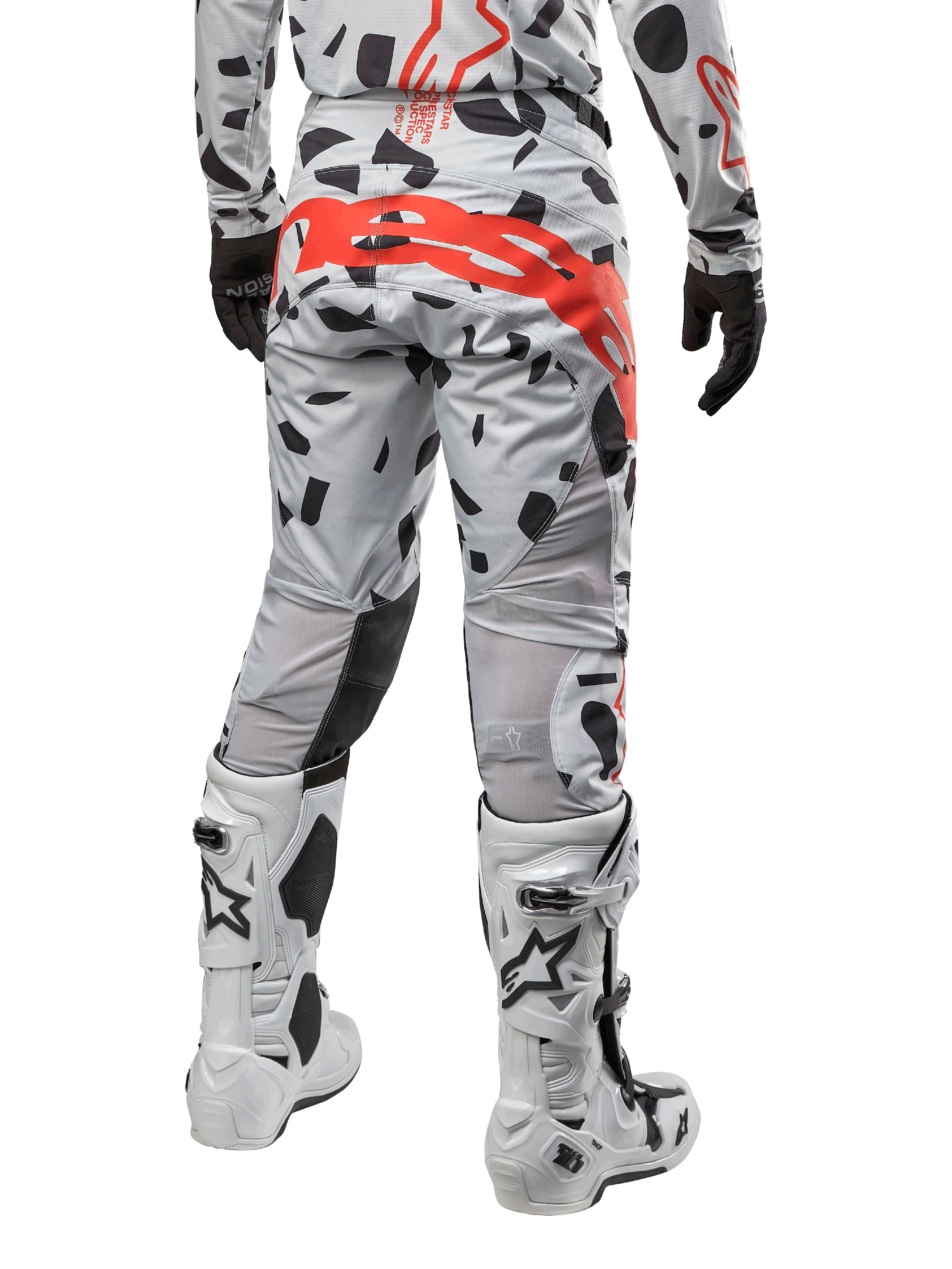Alpinestars 2024 Techstar Rantera-byxor, motocrossbyxor, Haze Gray Camo, med svarta kamouflagemönster och en stor röd Alpinestars-logotyp på sätet, sedda bakifrån tillsammans med vita stövlar och matchande racingutrustning