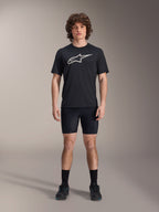 Alpinestars A-Dura Liner Shorts, svarta cykelinnerbyxor, bärs av en modell med en svart t-shirt med Alpinestars-logotyp och svarta cykelskor, tight passform för MTB-prestanda och komfort i sadeln.