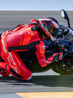 Alpinestars GP Plus V4 Sprint skinnställ 1-styck, röd fluo och vit, Tech-Air-redo racingoverall på förare i en kurva på banan.