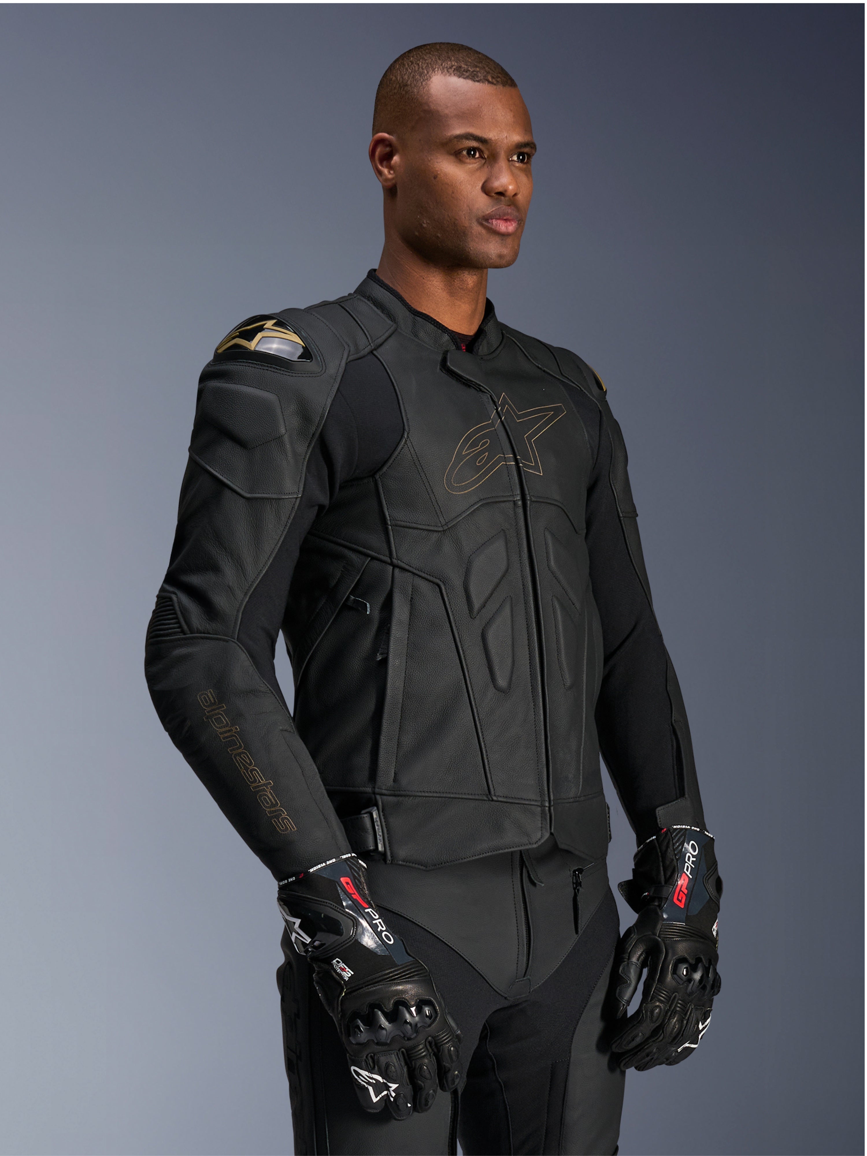 Alpinestars Dusk läderjacka, herr-MC-jacka för racing, svart läder med DFS-axelskydd och guldfärgad logotypkontur.