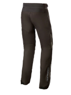 Alpinestars AST-1 V2 Waterproof Pants Long, svarta motorcykelbyxor i textil, vy bakifrån som visar reflekterande detaljer och vertikal logotyp på underbenet, slitstark allvädersutrustning