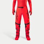 Alpinestars Supertech Ember LE byxor, motocrossbyxor, Red Fluo och klarröda med svarta detaljer, med framträdande svarta stjärnlogotyper på låren, svart midjespänne och knäpaneler, bärs med matchande röda stövlar och handskar för en koordinerad racingoutfit.