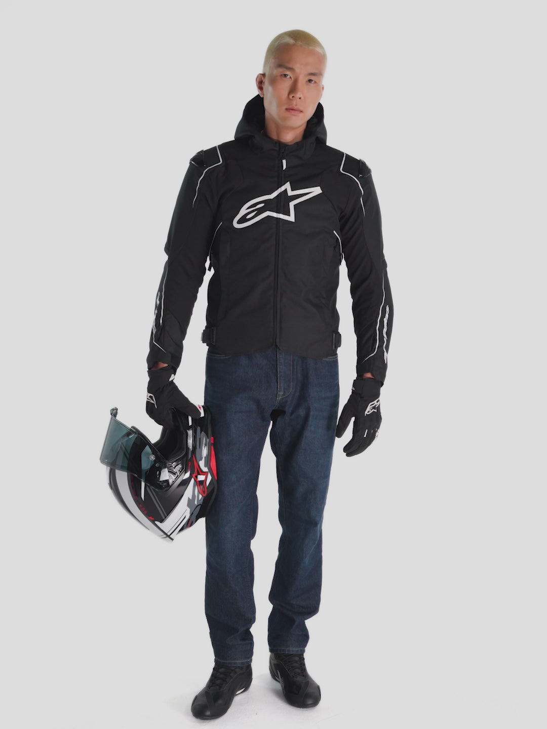 Alpinestars Zaca V2 Waterproof Jacket, men's textile motorcycle racing jacket in black and white, worn by a model showcasing waterproof construction and protective features.